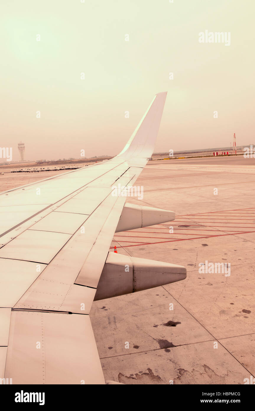 Flugzeugflügel über Flughafen-Start-und Landebahn-Spur Stockfoto