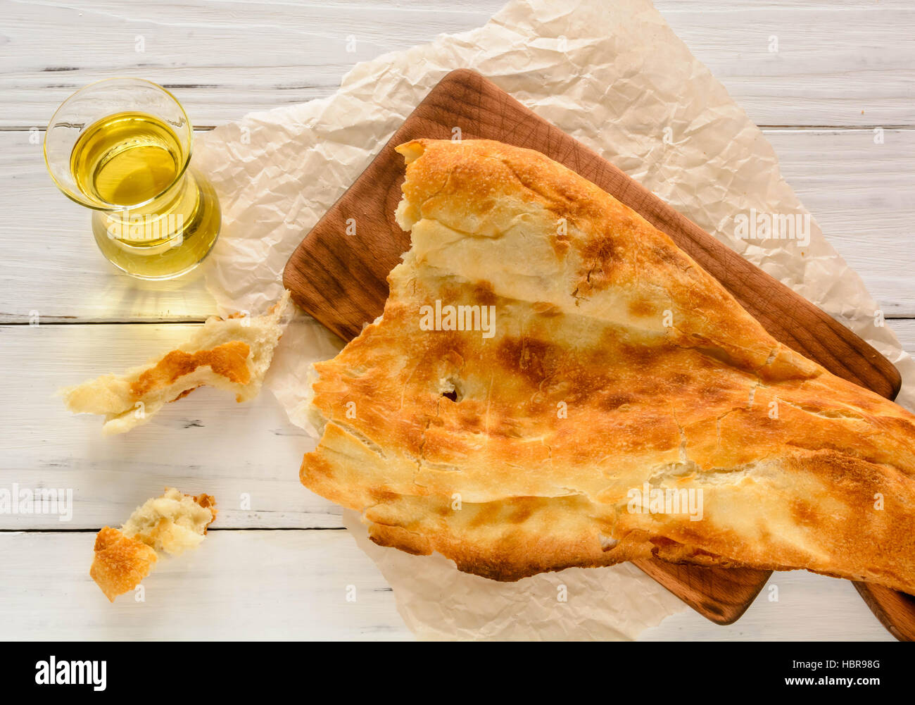 halbes Fladenbrot kaukasischen, liegend auf einem Schneidebrett gebrochen. Hellen Holz Hintergrund. Stockfoto