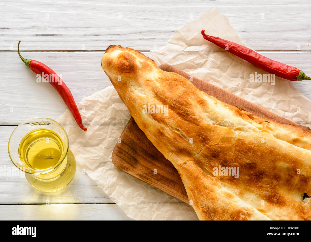 halbes Fladenbrot kaukasischen, liegend auf einem Schneidebrett gebrochen. Hellen Holz Hintergrund. Stockfoto
