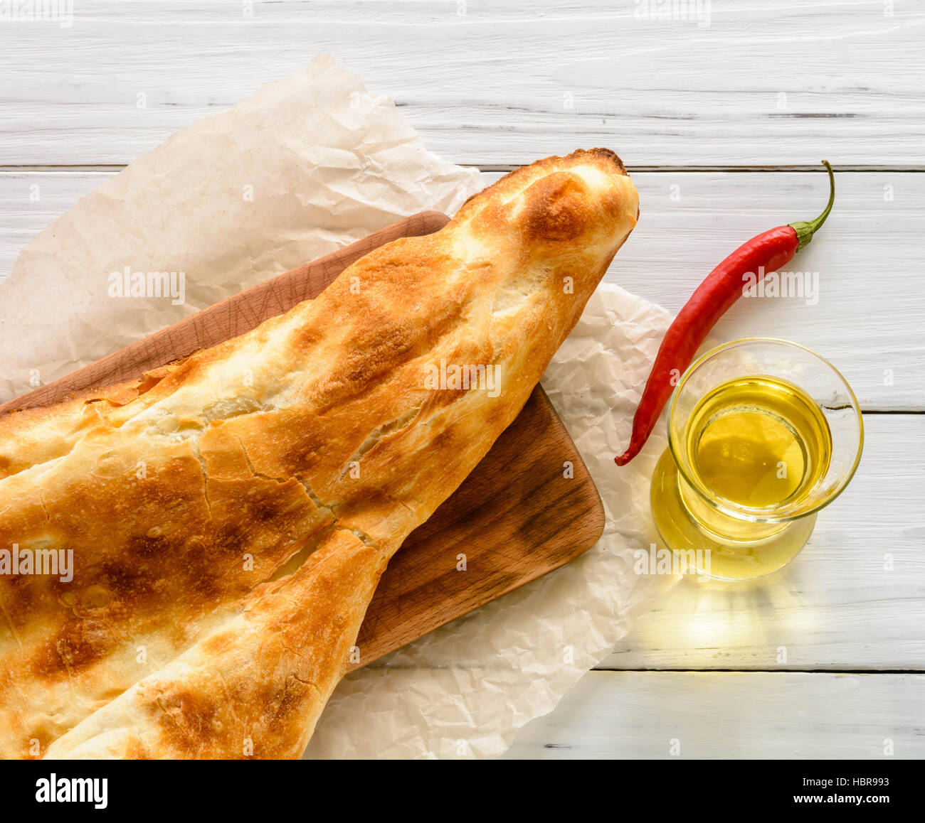 halbes Fladenbrot kaukasischen, liegend auf einem Schneidebrett gebrochen. Hellen Holz Hintergrund. Stockfoto