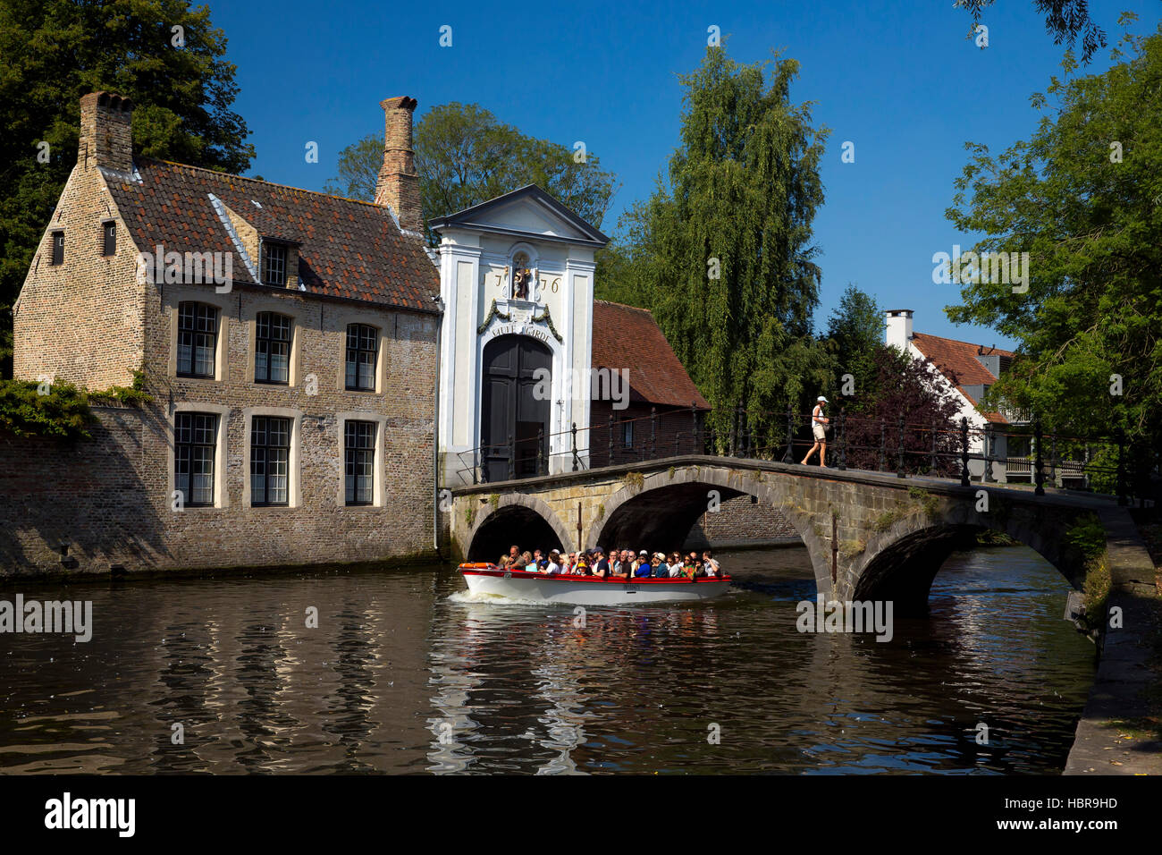 Touristenboot am Minnewater See und Begijnhof Brücke mit Eingang zum Beginenhof, Brügge, Belgien, Europa Stockfoto
