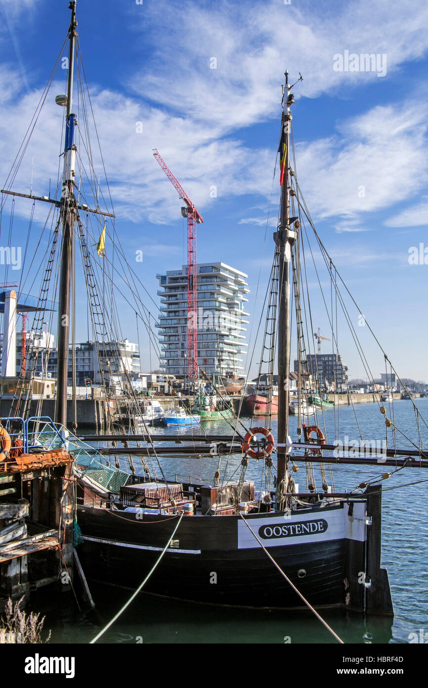 Zweimaster Segelschiff Nele und neue Wohnungen zu bauen für Immobilien-Projekt Oosteroever im Hafen von Ostende an der belgischen Nordseeküste Stockfoto