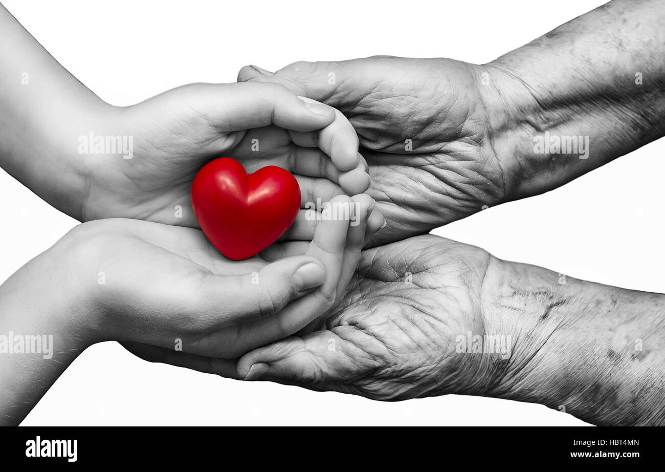 kleine Mädchen und ältere Frau zusammenhalten rotes Herz in ihre Handflächen, isoliert auf weißem Hintergrund, Symbol der Liebe und Sorgfalt Stockfoto