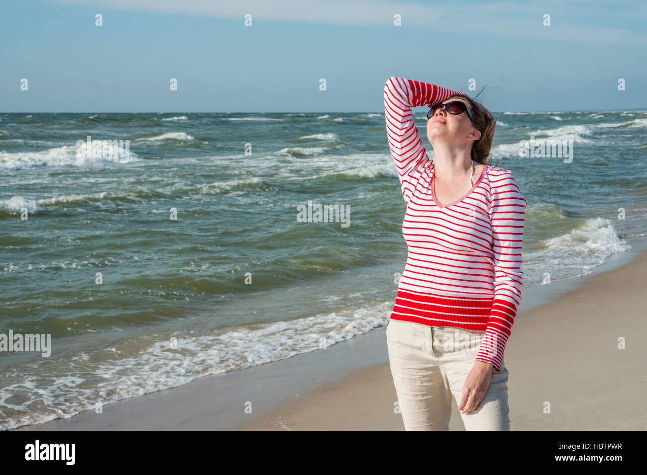 Entspannte Frau stand in der Nähe des Meeres Stockfoto