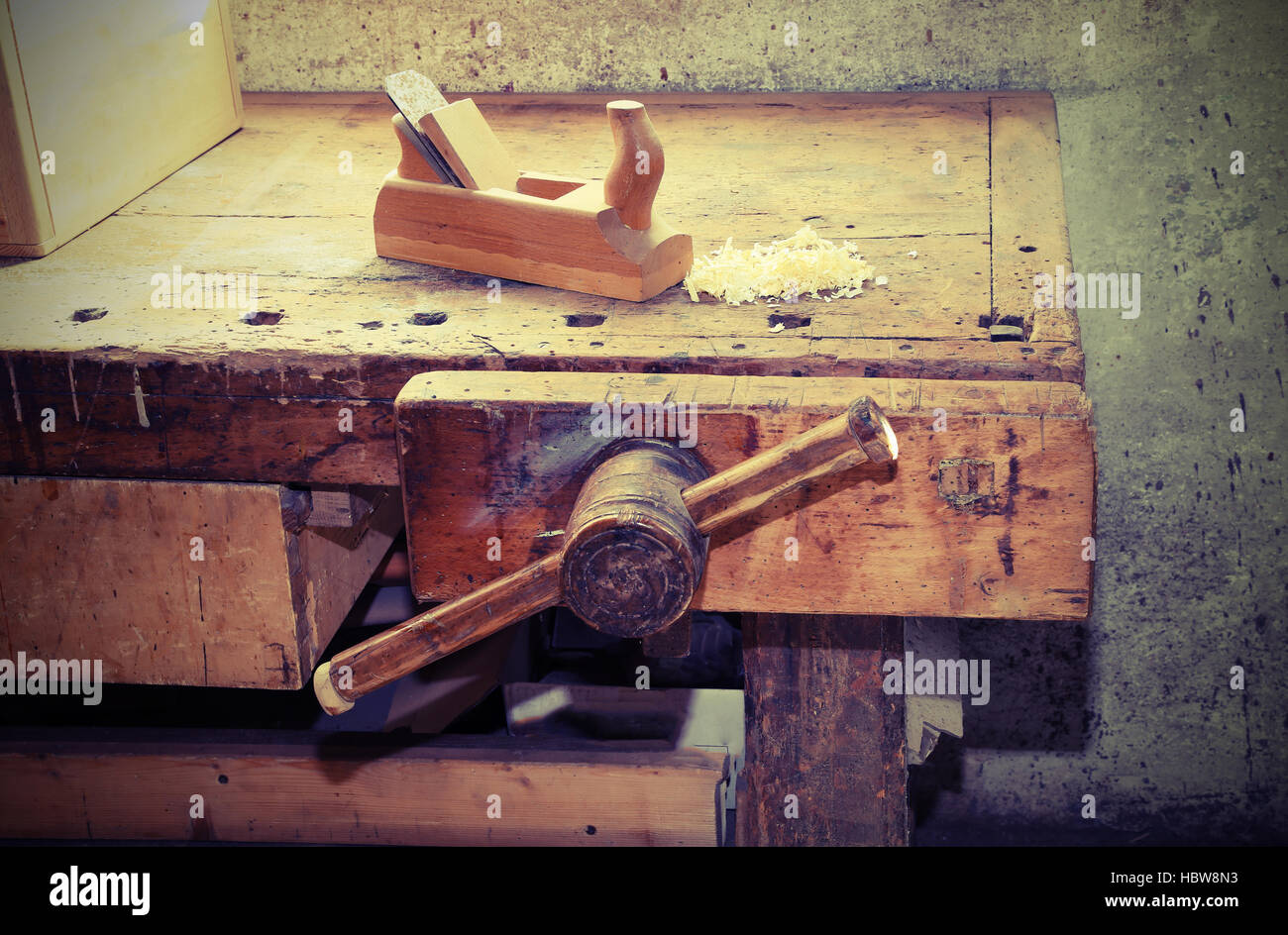 altes Holz Flugzeug auf dem Tisch der Werkstatt von Zimmermann mit einem hölzernen Schraubstock Stockfoto