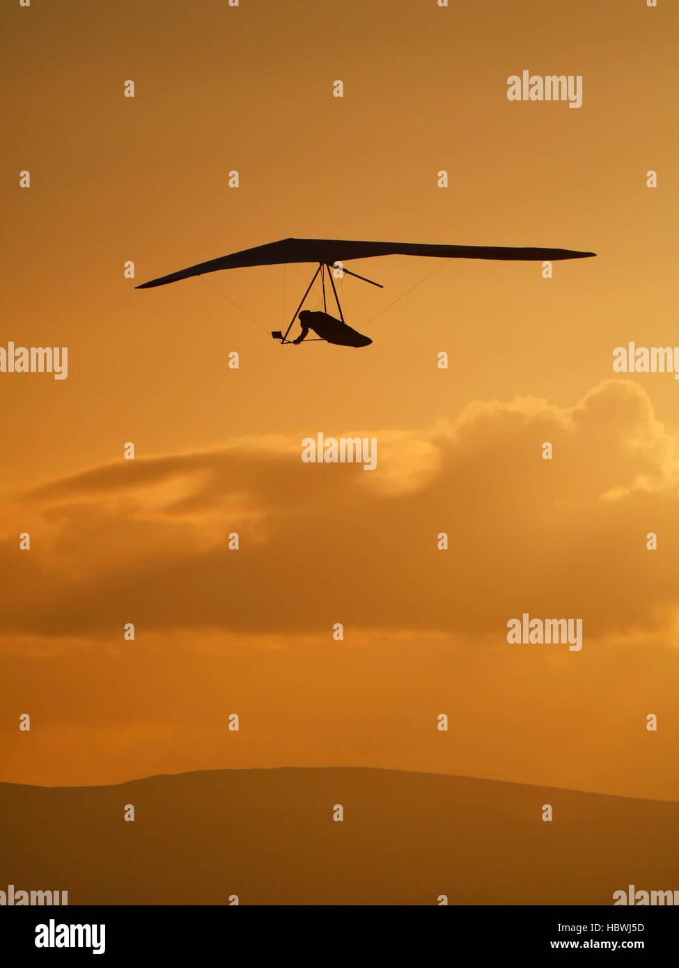 Hängegleiter fliegen gegen Sonnenuntergang Himmel Stockfoto