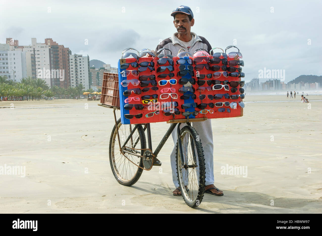 Menschen aus Brasilien, Mann, der Sonnenbrillen am Praia Grande Beach im Bundesstaat Sao Paulo verkauft. Stockfoto