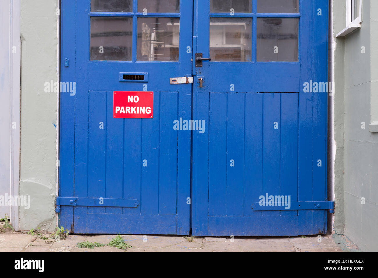 Red No Parking Schild vor blaue Tür, Hastings Stockfoto