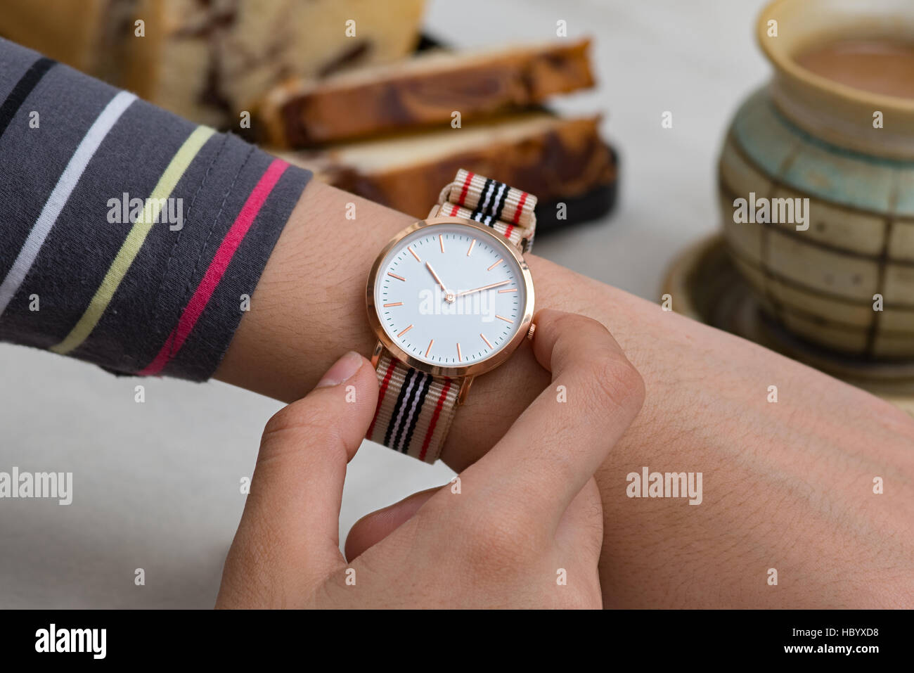 Mädchens Hand mit Handgelenk Uhren bei der Kaffeepause vor heiße Schokolade und Kuchen Stockfoto