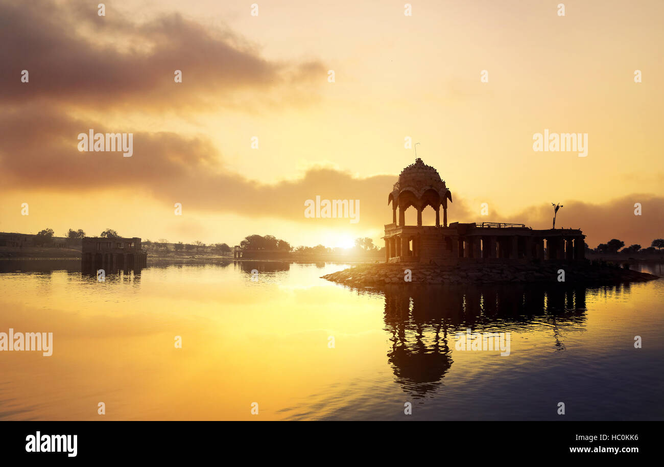 Silhouette des Tempels auf dem Gadi Sagar See gelbe Sonnenuntergang Himmel in Jaisalmer, Rajasthan, Indien Stockfoto