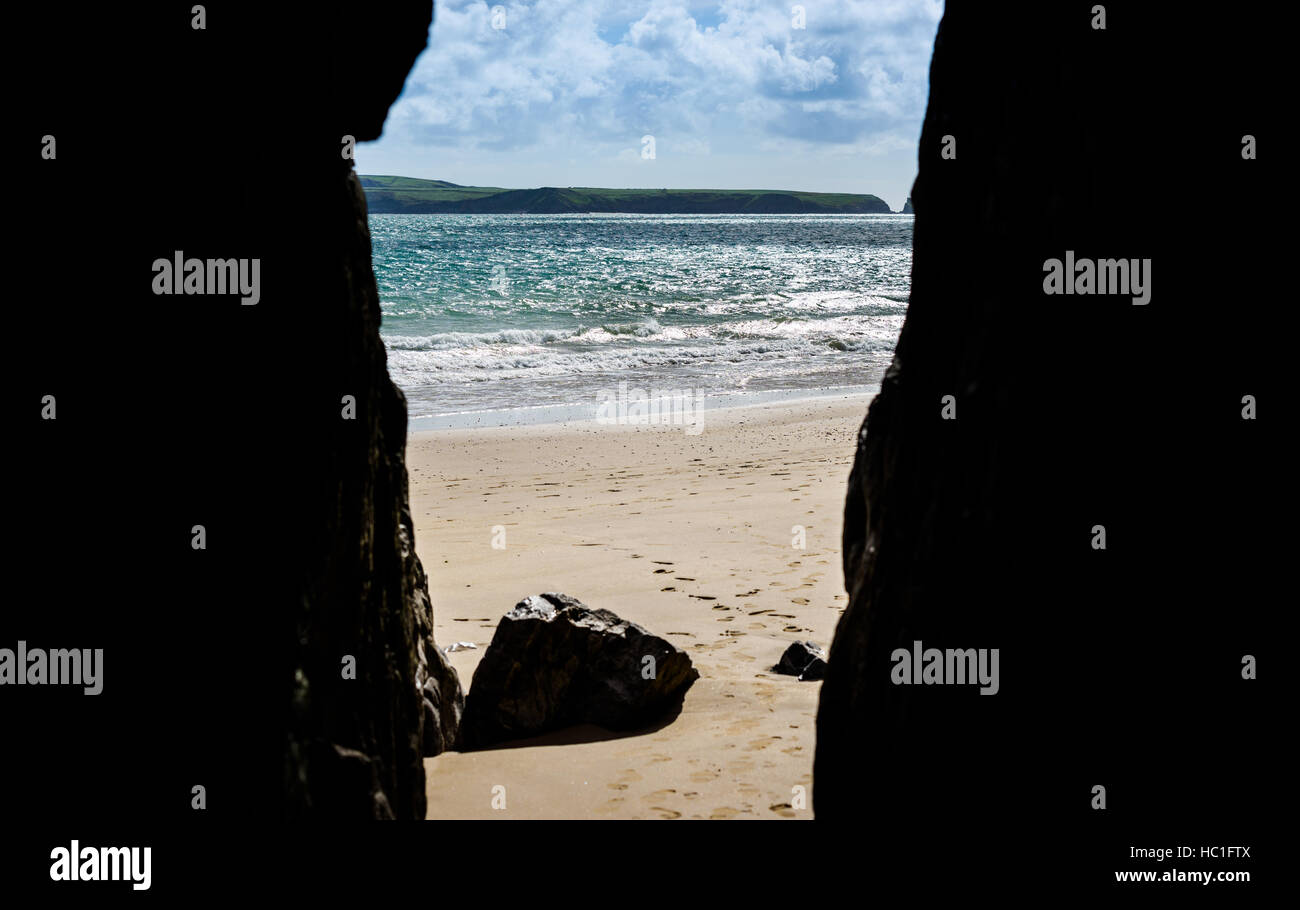 Durch eine Höhle auf einen Strand suchen Stockfoto