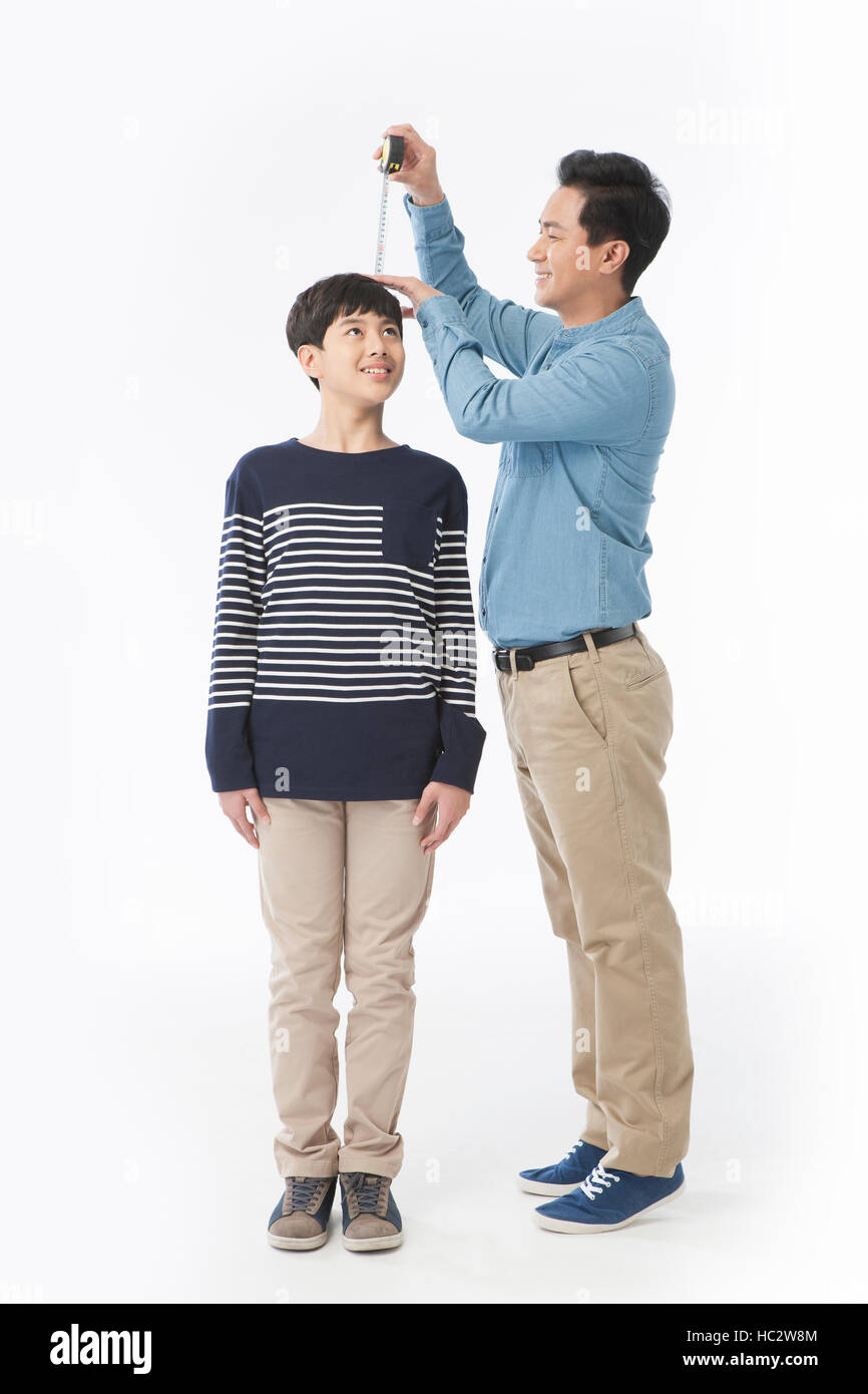 Applying liebenden Vater seine dreizehn-Jahr-alten Sohn Höhe messen Stockfoto