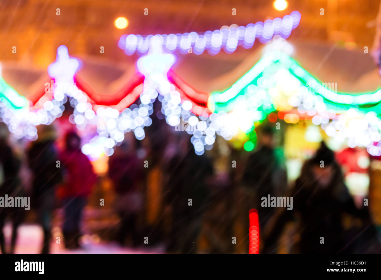 verschneite Straße mit Urlaub Beleuchtung außerhalb des Fokus auf Dezembernacht Stockfoto