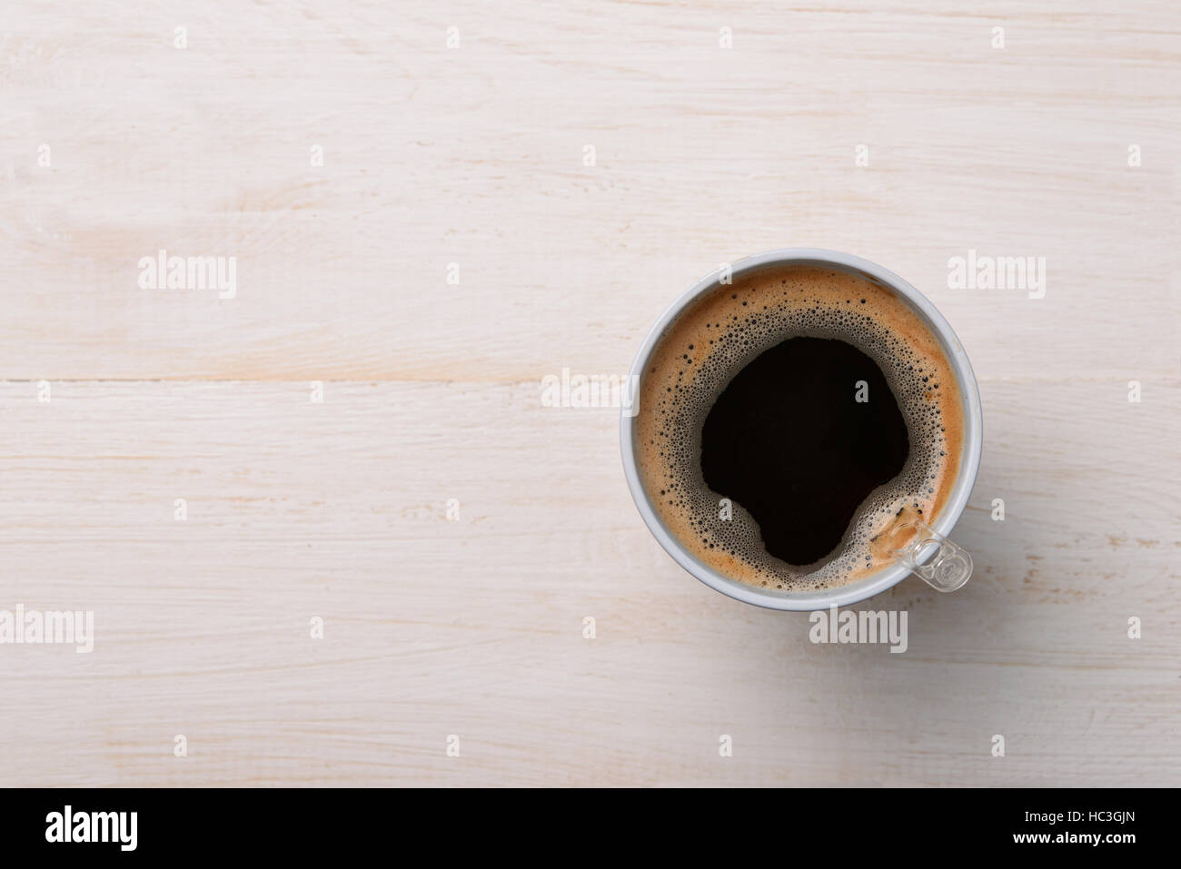 Draufsicht der schwarzen Kaffee im Plastikbecher auf weißer Holztisch Stockfoto