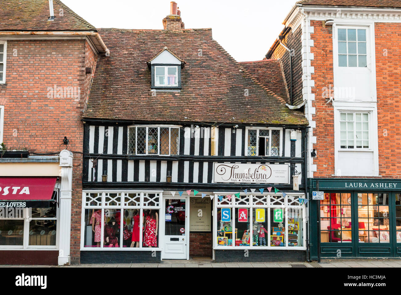 15. Jahrhundert weißen Putz und schwarzen Holzrahmen Gebäude. "Thumbelina', Kleidung und Spielzeug Shop im High St, (Hauptstraße), Tenderden, England. Stockfoto