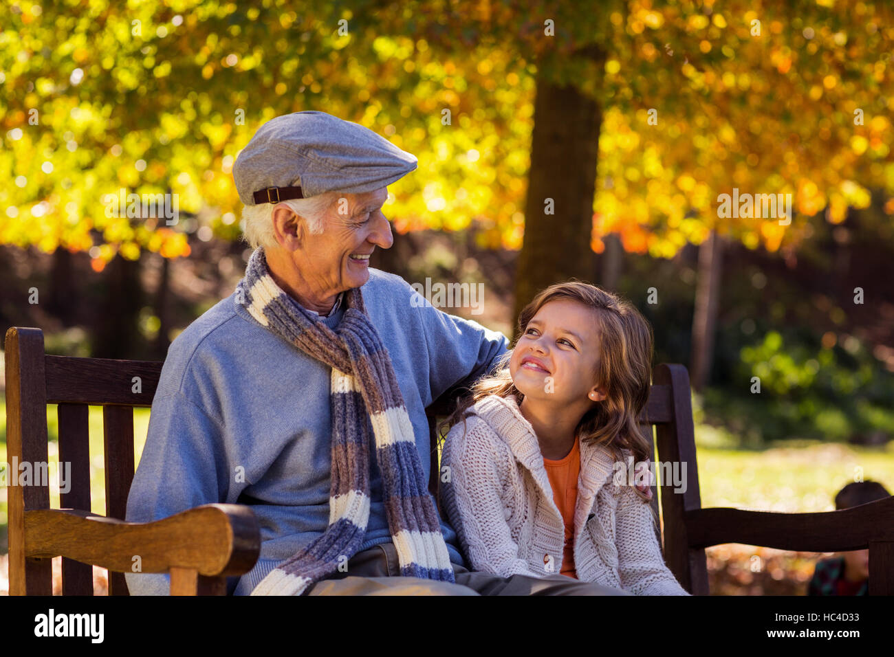 Großvater mit Enkelin im Park sitzend Stockfoto