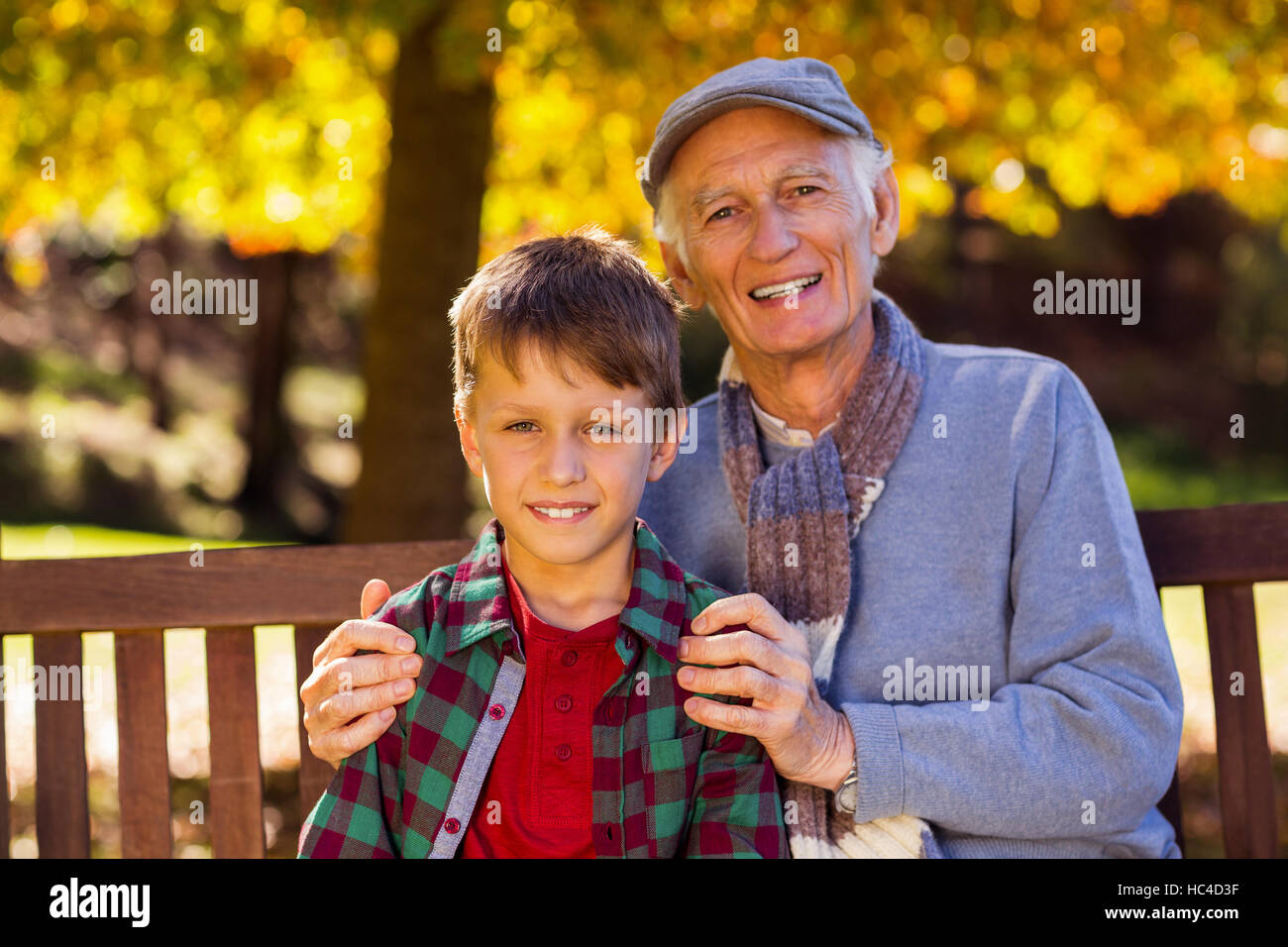 Großvater mit Enkel im Park sitzend Stockfoto