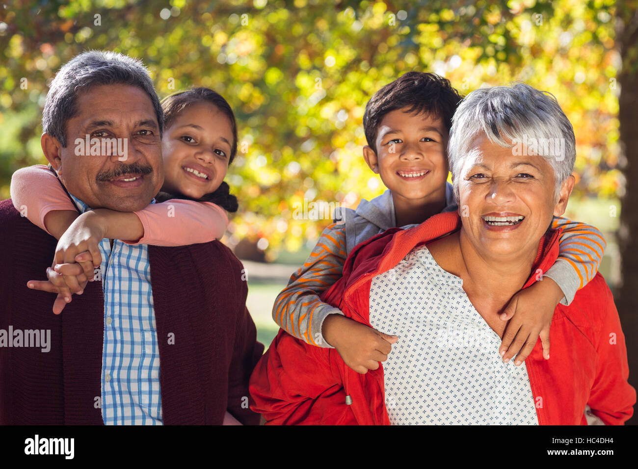 Glückliche Großeltern Huckepack Enkel im park Stockfoto