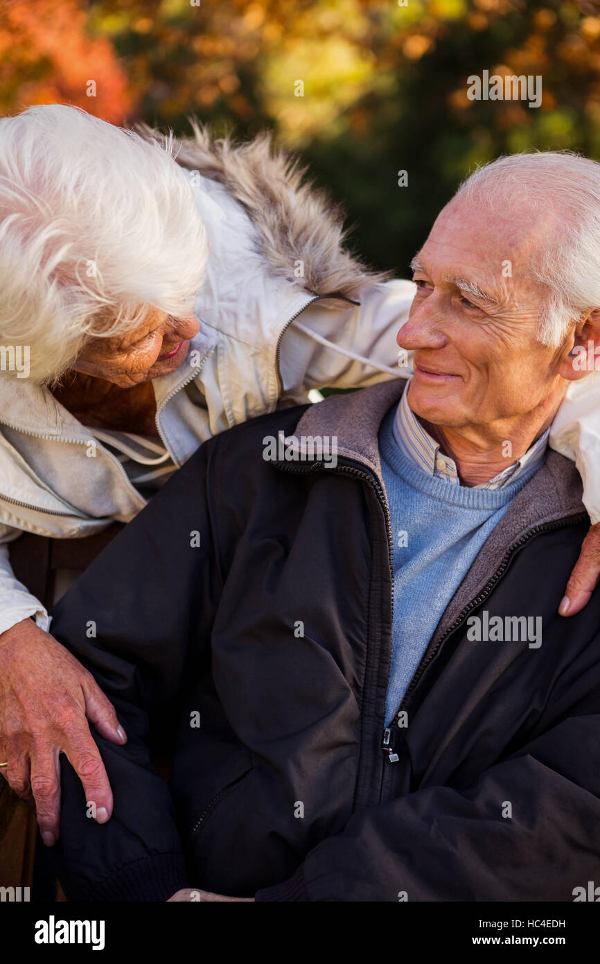 Ein senior Frau zärtlich betrachten ihr Mann sitzen Stockfoto