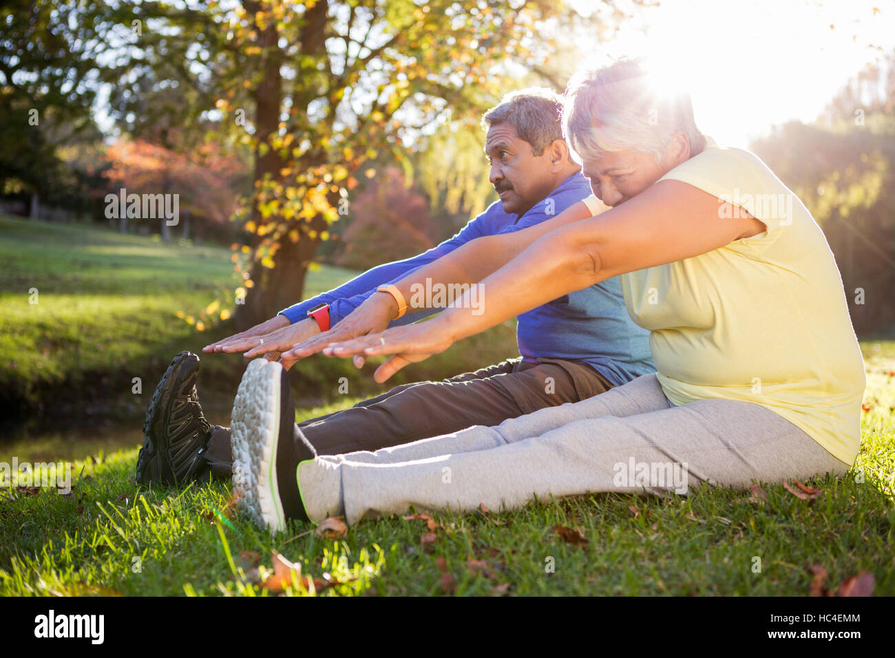 Älteres paar stretching auf Feld im park Stockfoto