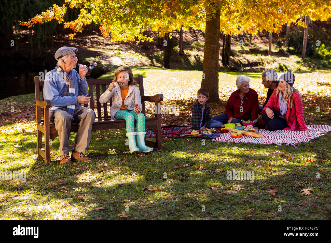 Familie picknicken und der Großvater mit seiner Enkelin spielen Stockfoto