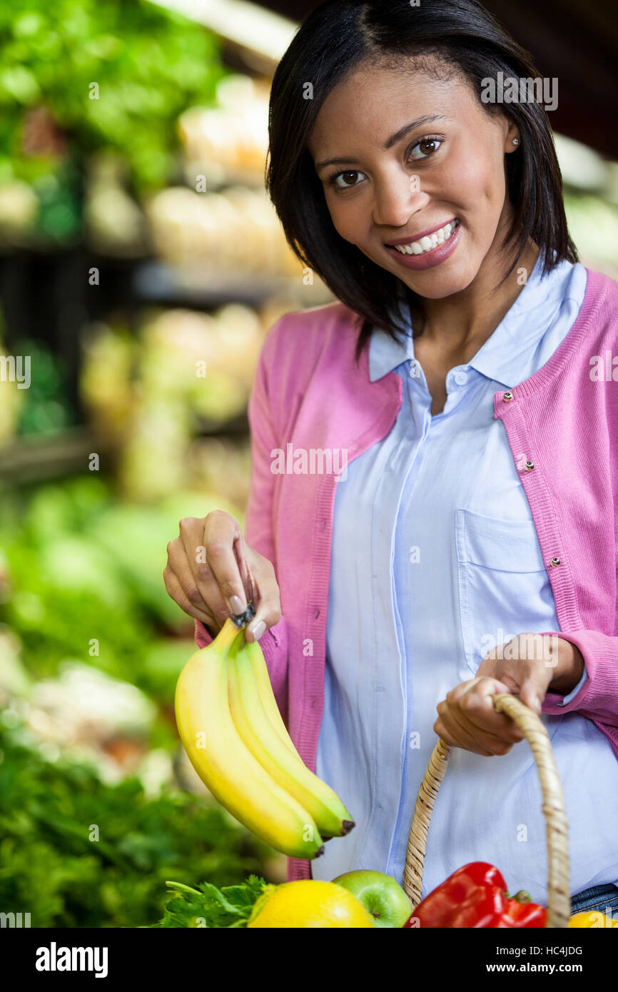 Frau, die Banane im organischen Bereich kaufen Stockfoto