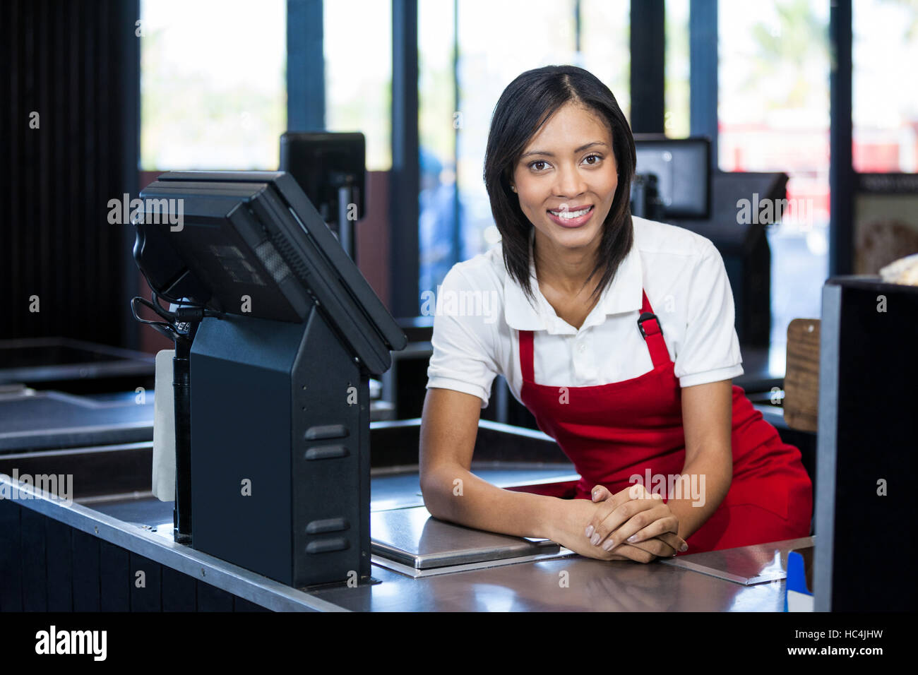 Weibliches Personal an der Kasse sitzen Stockfoto