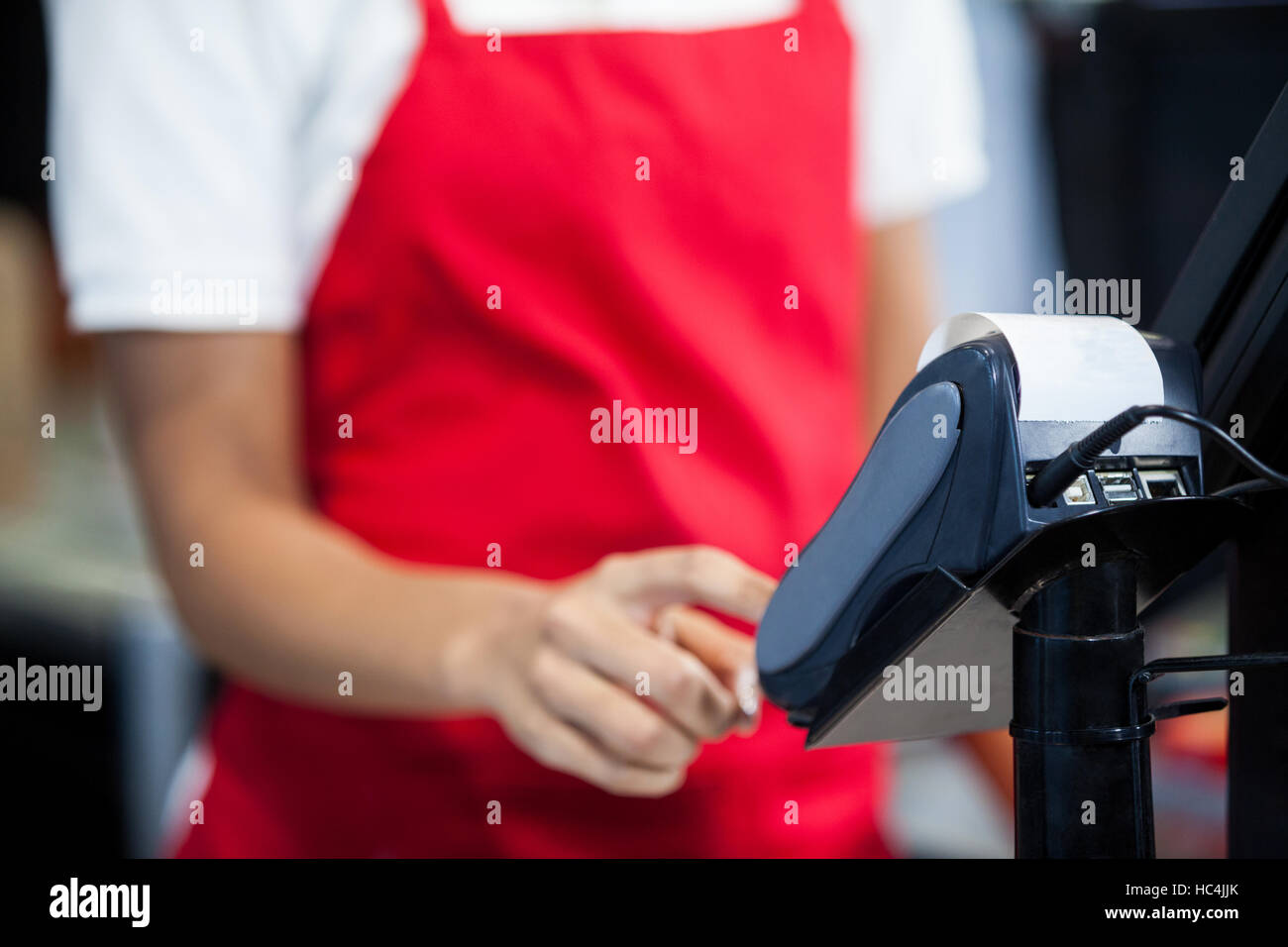Mitarbeiterinnen mit Kreditkartenterminal bei Kasse Stockfoto