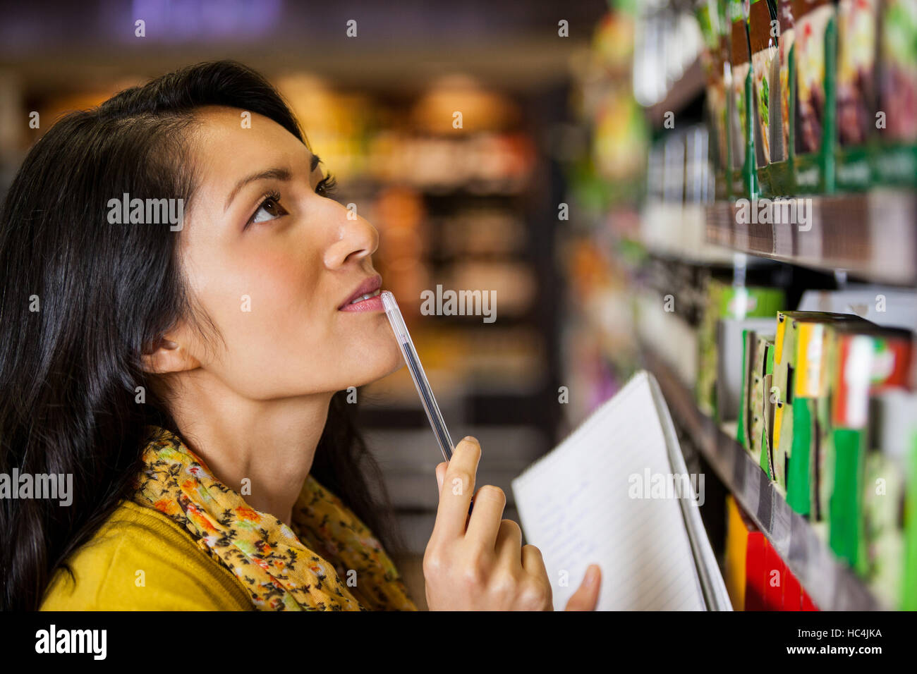 Nachdenkliche Frau einkaufen für Lebensmittel Stockfoto