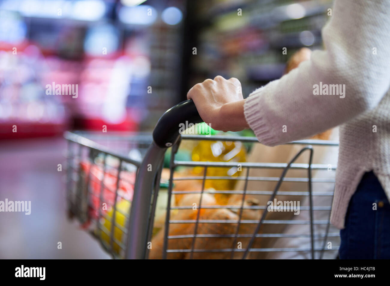 Frau hält Lebensmittel im Warenkorb Stockfoto