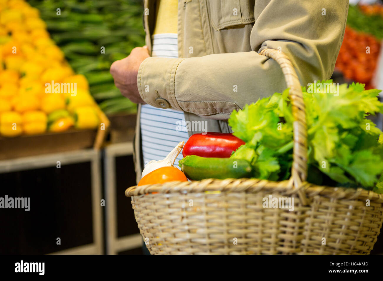 Mann hält einen Korb mit Gemüse im Supermarkt Stockfoto