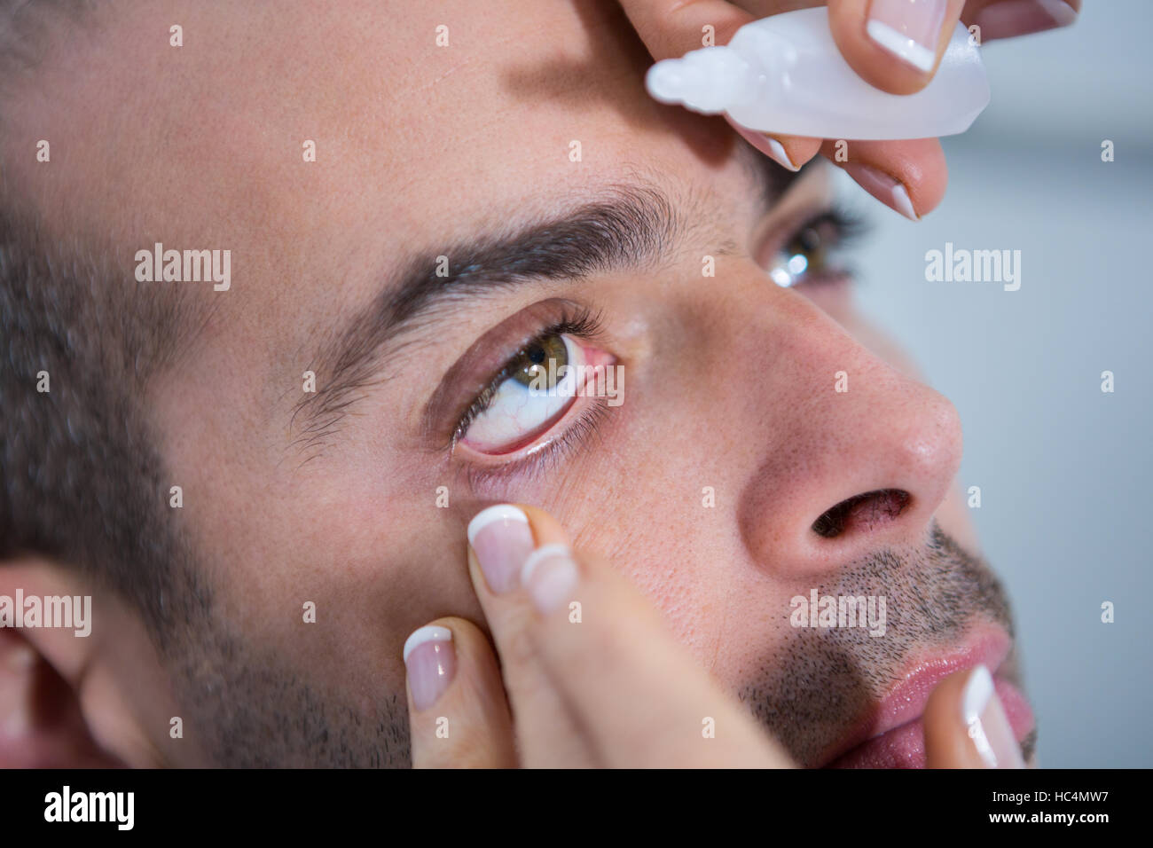 Optiker setzen fällt in die Augen des Patienten Stockfoto