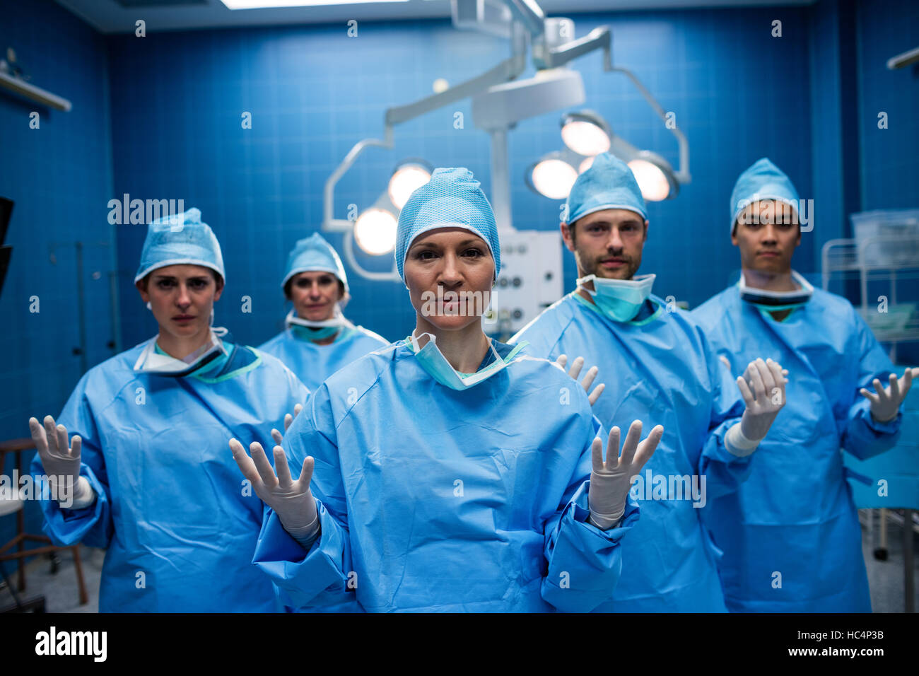 Porträt des Chirurgen stehend mit Handzeichen im OP-Saal Stockfoto