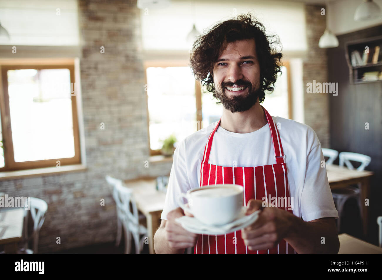 Männliche Bäcker hält eine Tasse Kaffee Stockfoto
