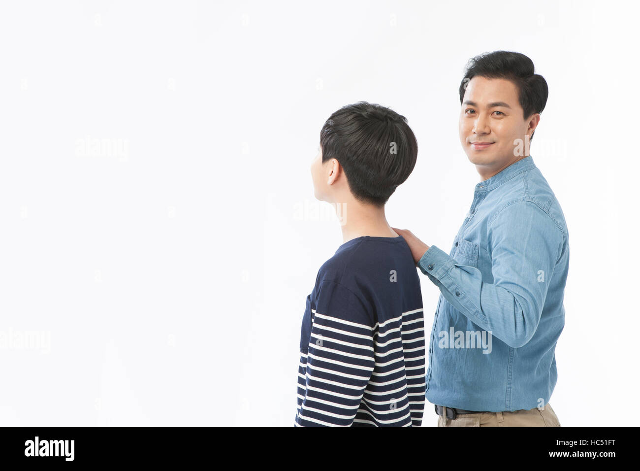 Seitenansicht des Lächelns Mitte im Alter Vater seinen Sohn auf die Schulter berühren Stockfoto