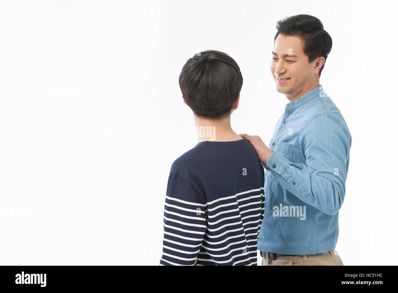 Seite Ansicht Porträt des lächelnden Vater seinen Sohn auf die Schulter von Angesicht zu Angesicht zu berühren Stockfoto