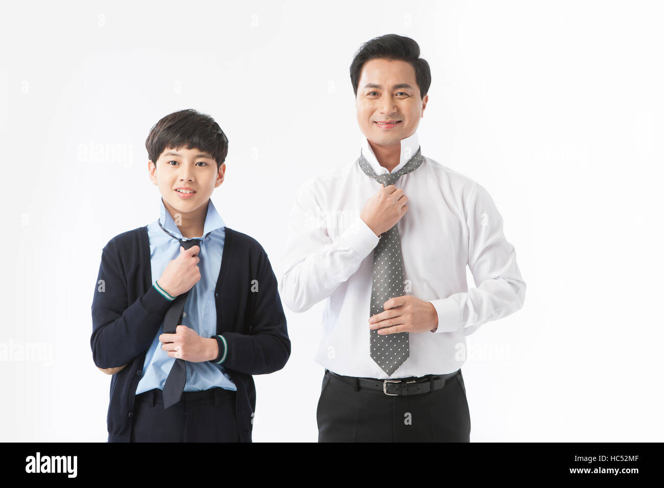Lächelnd, Sohn und Vater tragen ihre Krawatten Stockfoto