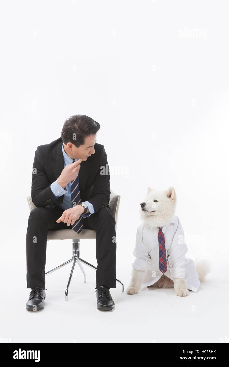 Lächelnd Mitte im Alter Geschäftsmann und sein Hund von Angesicht zu Angesicht Stockfoto