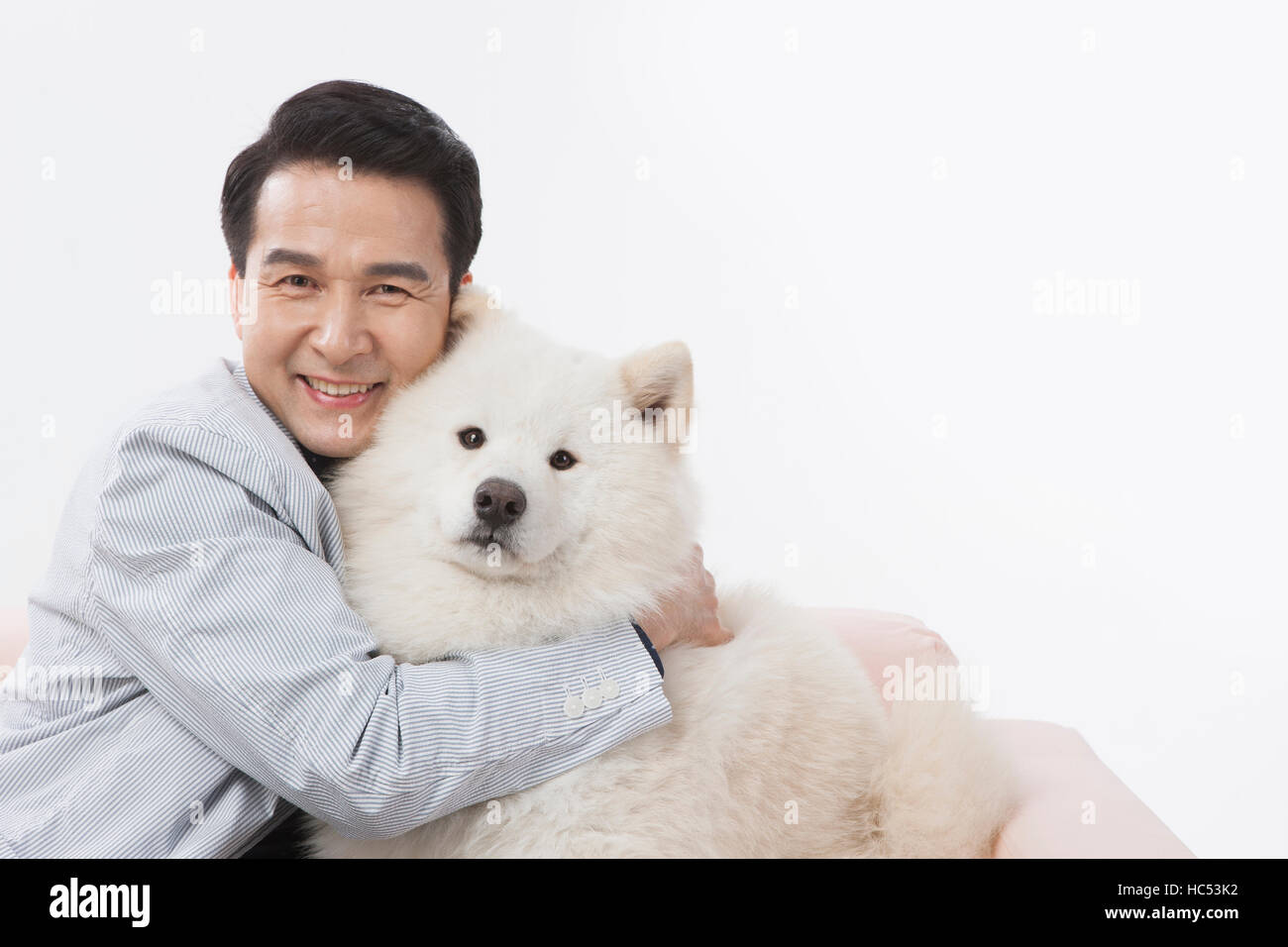 Porträt des Lächelns Mitte im Alter Mann umarmt seinen Hund Stockfoto