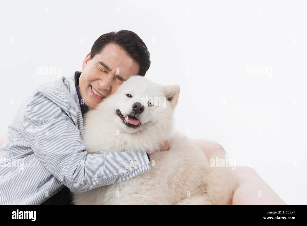 Porträt des Lächelns Mitte im Alter Mann umarmt seinen Hund Stockfoto