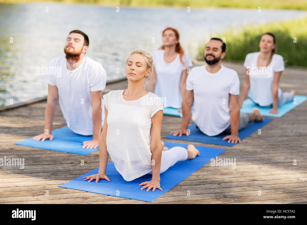Gruppe von Menschen, die Yoga-Übungen im freien Stockfoto