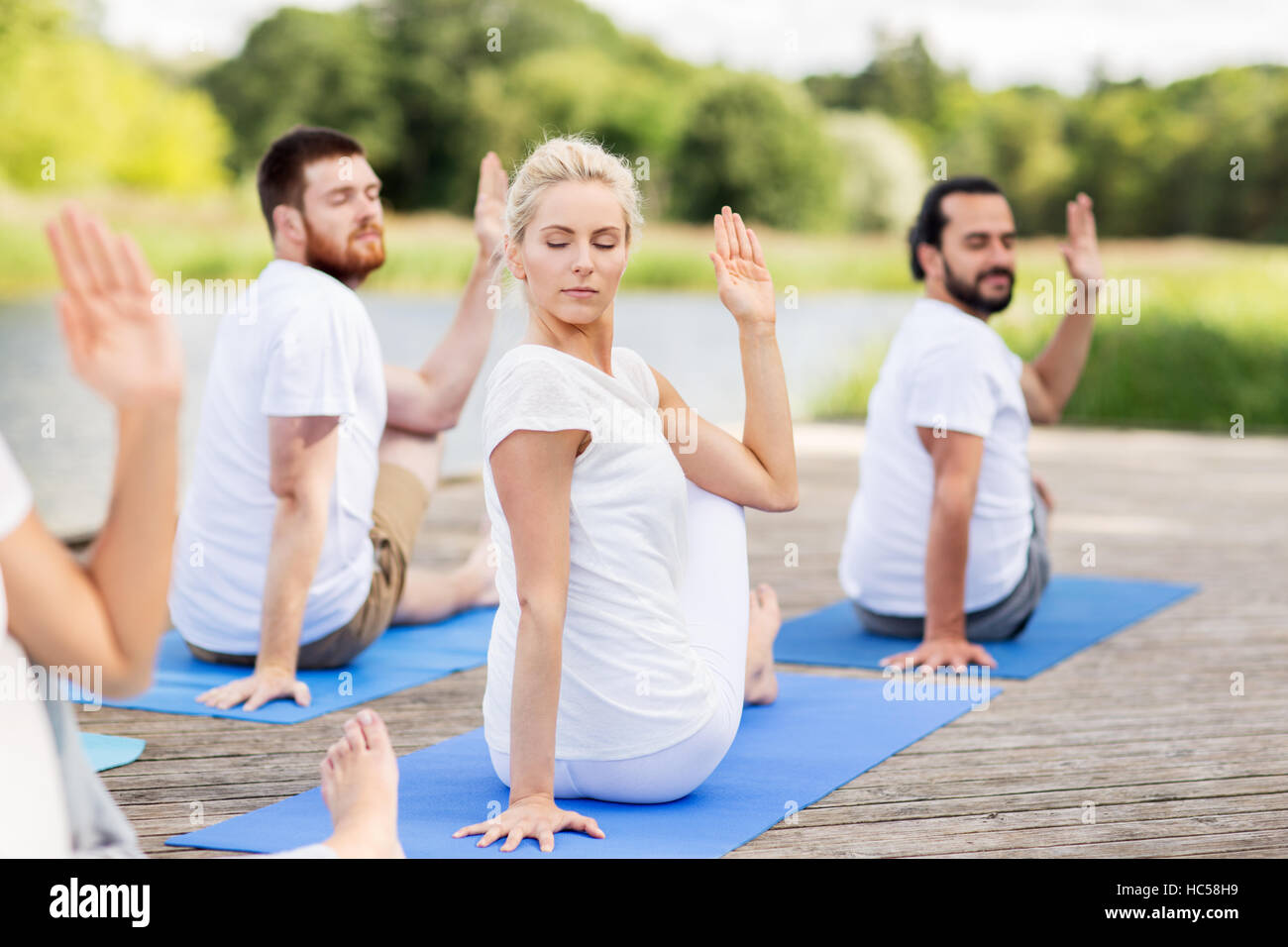 Menschen, die Yoga auf eine halbe Herrn der Fische darstellen Stockfoto