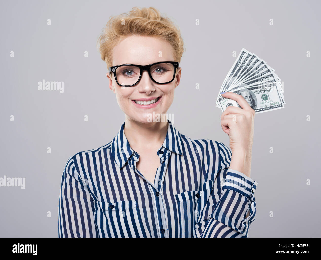 Fröhliche Frau mit einem Fächer aus Geld Stockfoto