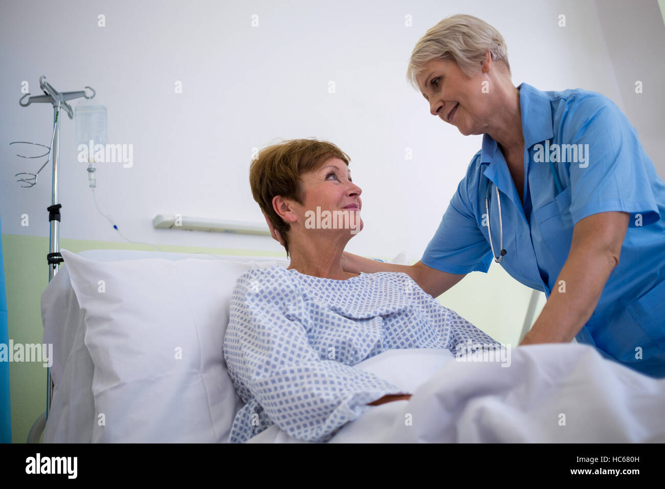 Krankenschwester im Gespräch mit einem älteren Patienten Stockfoto