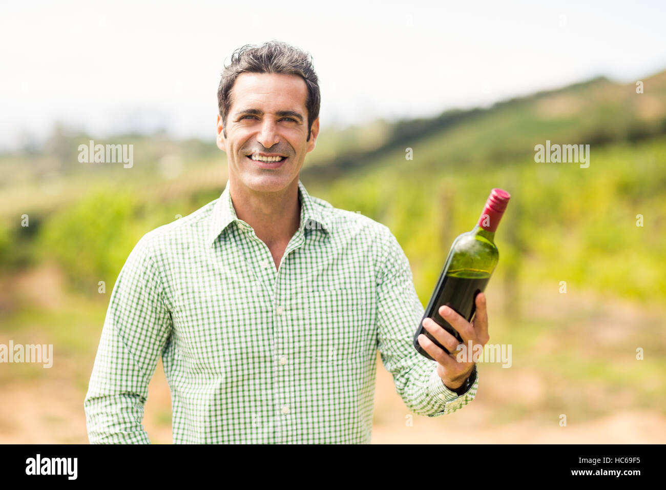 Lächelnd hält Flasche Wein Winzer Stockfoto
