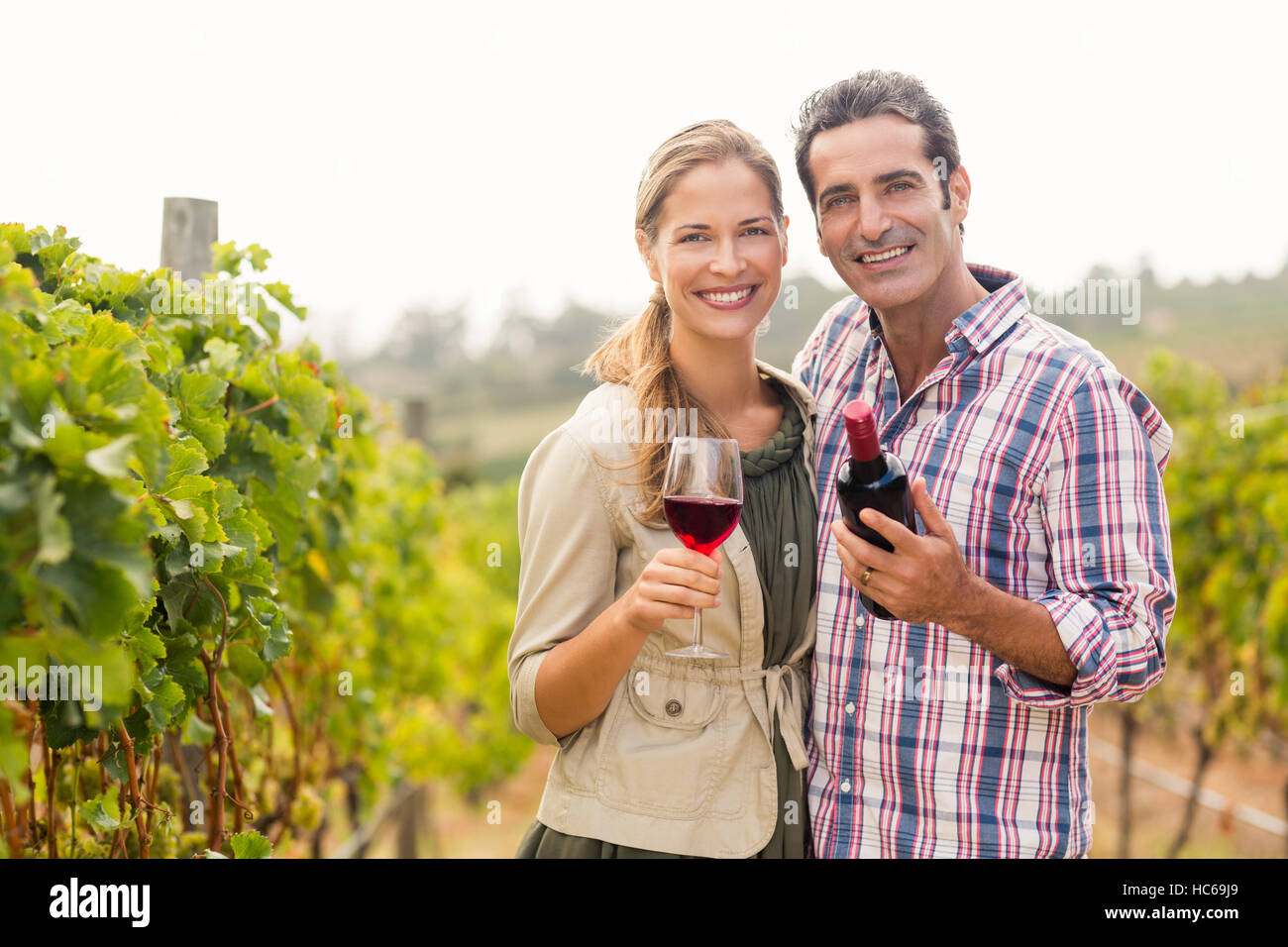 Porträt des glücklichen Paares halten Glas und eine Flasche Wein Stockfoto