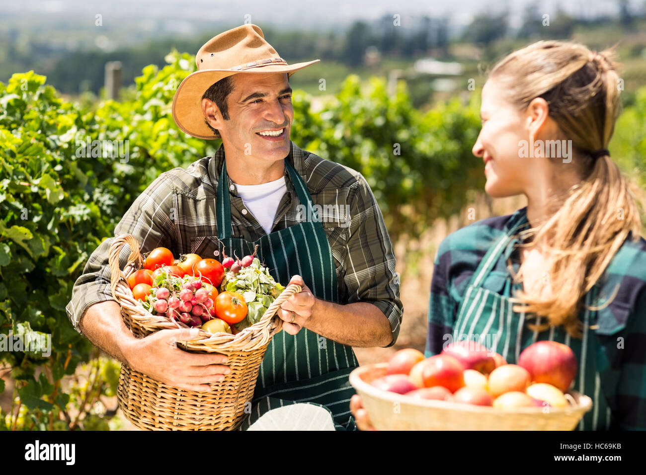 Glücklich Landwirt paar Körbe mit Obst und Gemüse halten Stockfoto