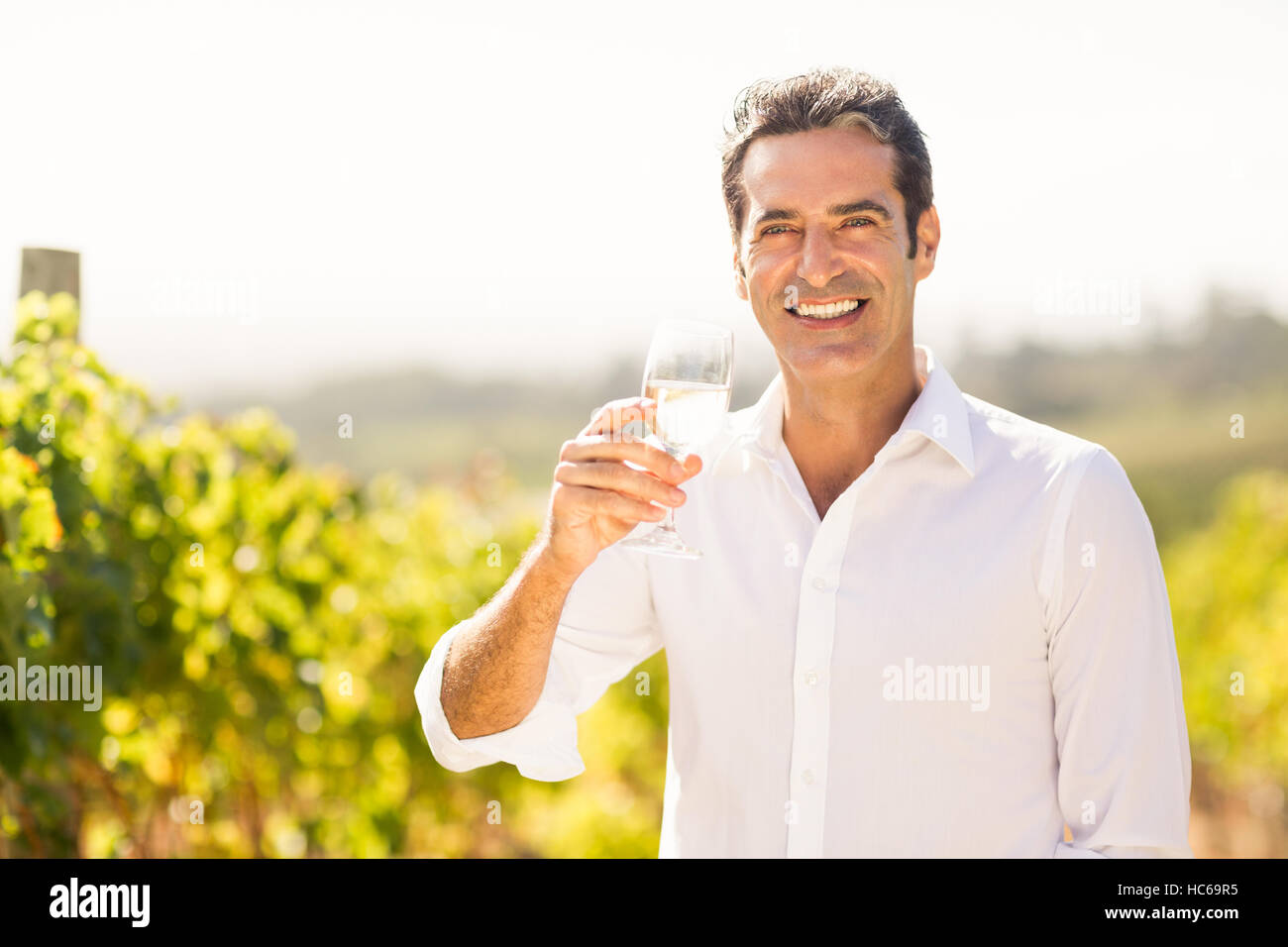 Porträt von lächelnden männlichen Winzer mit einem Glas Wein Stockfoto