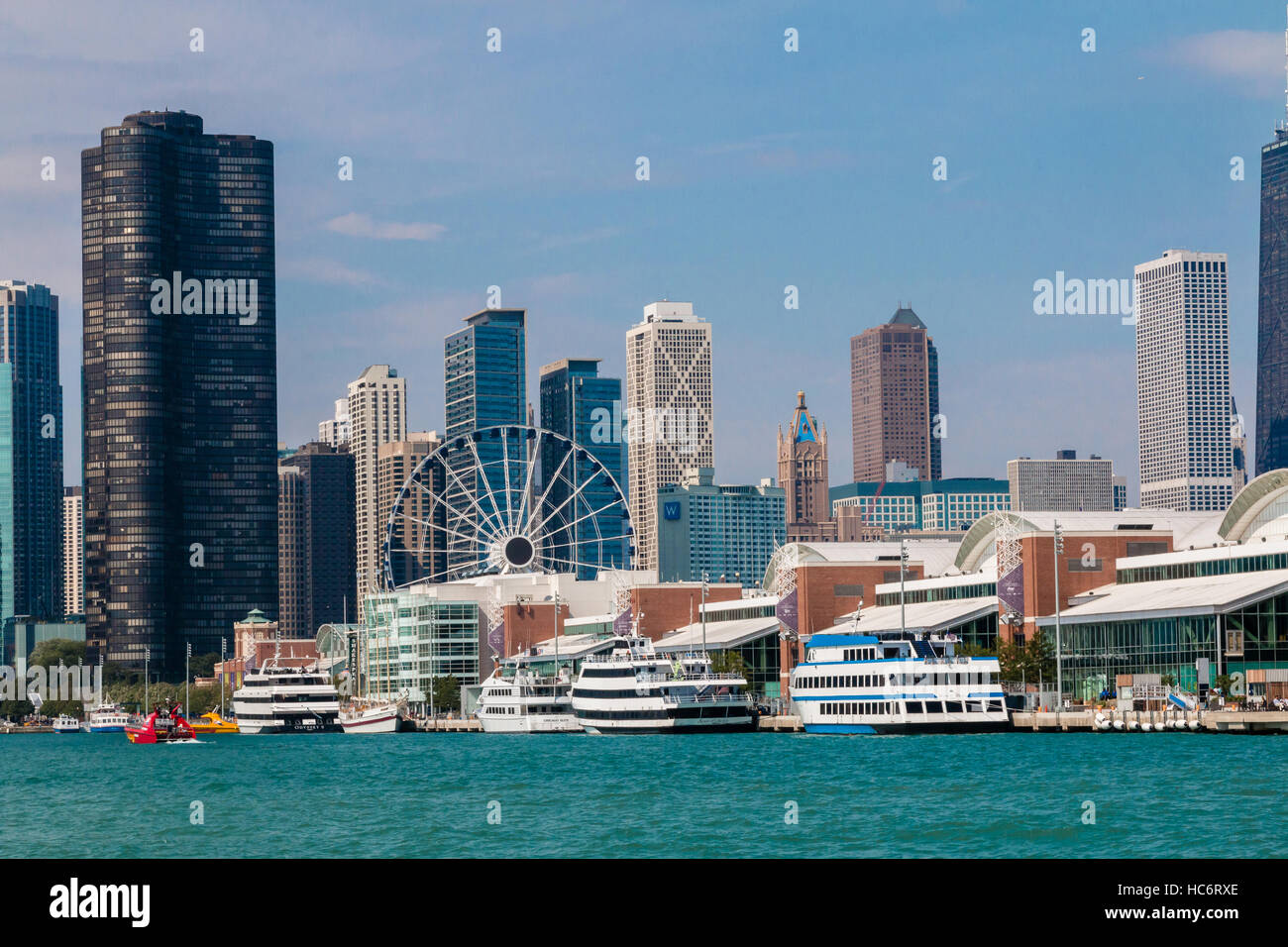 Das Navy Pier in Chicago, Illinois mit Kreuzfahrtschiffen und Ausflugsboote und Riesenrad vor der Skyline von Chicago Stockfoto