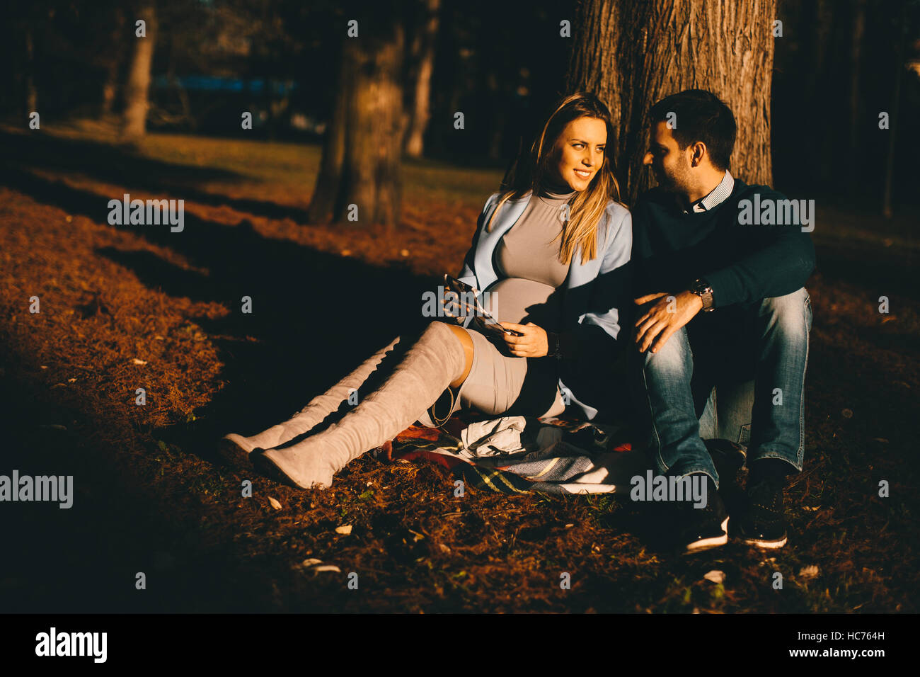 Schwangere Frau und Mann posiert im Herbst park Stockfoto